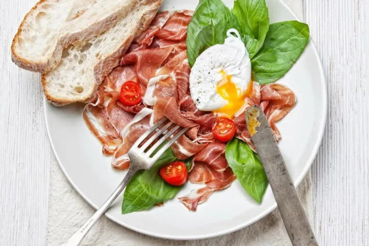 Œufs aux tomates servis avec pain grillé et herbes fraîches