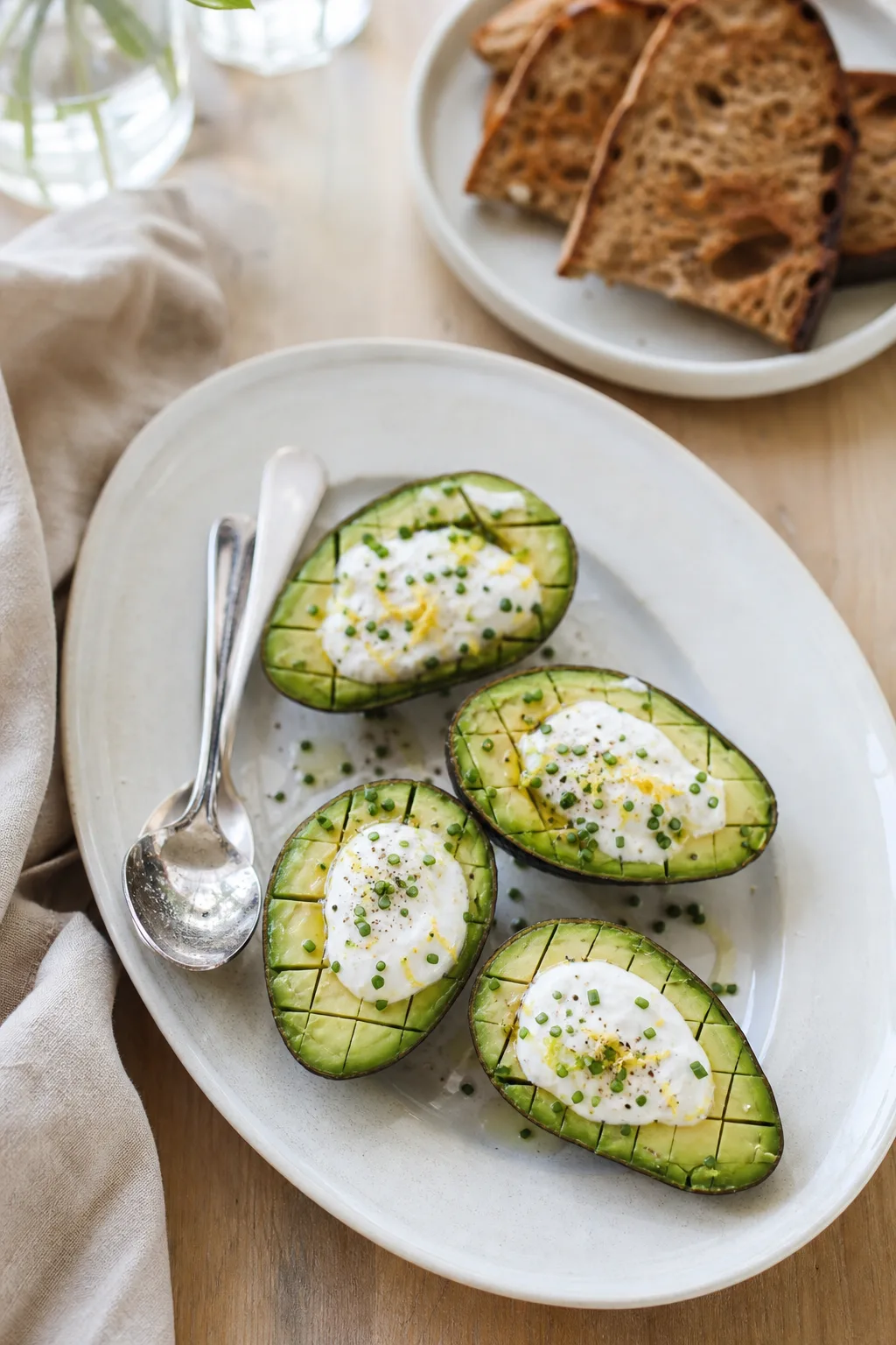 Demi-avocats quadrillés garnis de sauce blanche, ciboulette et zeste de citron